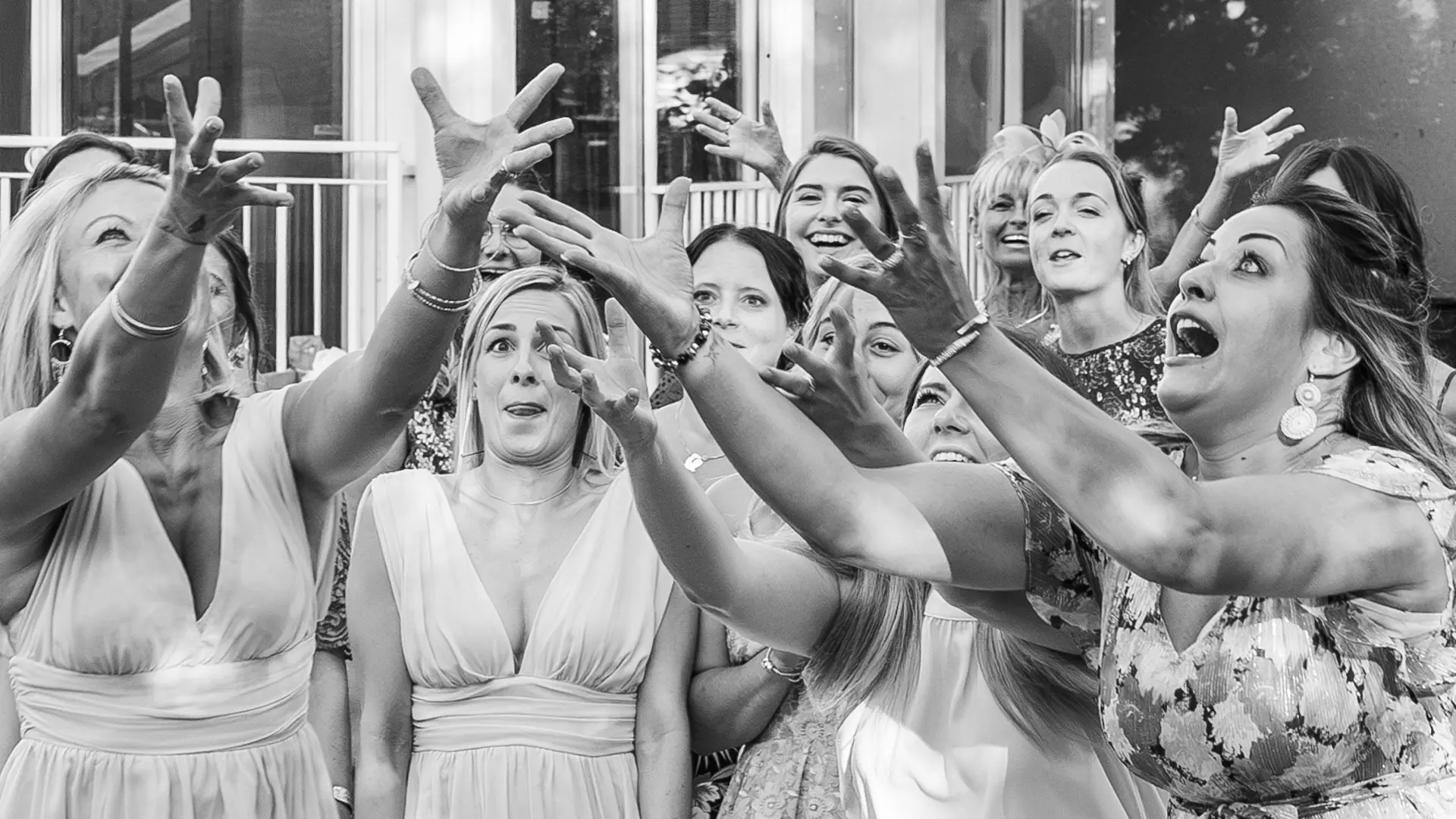 Photo en noir et blanc d'un groupe d'enfants, garçons et filles, courant joyeusement vers l'avant sur une pelouse. Un garçon au centre a la bouche ouverte, comme s'il criait de joie. Un adulte est visible en arrière-plan près d'un food truck.